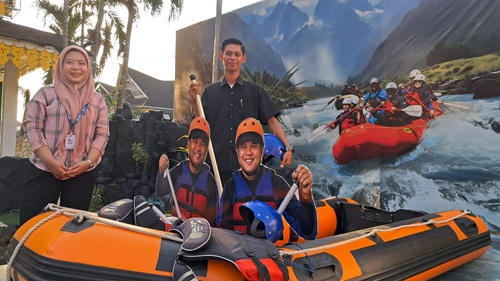 Pemandu Paviliun Serdang Bedagai berfoto di depan boat arung jeram Bah Bolon di PRSU 2026 di Medan. Destinasi tersebut menjadi salah satu yang paling banyak ditanyakan selama pameran berlangsung.